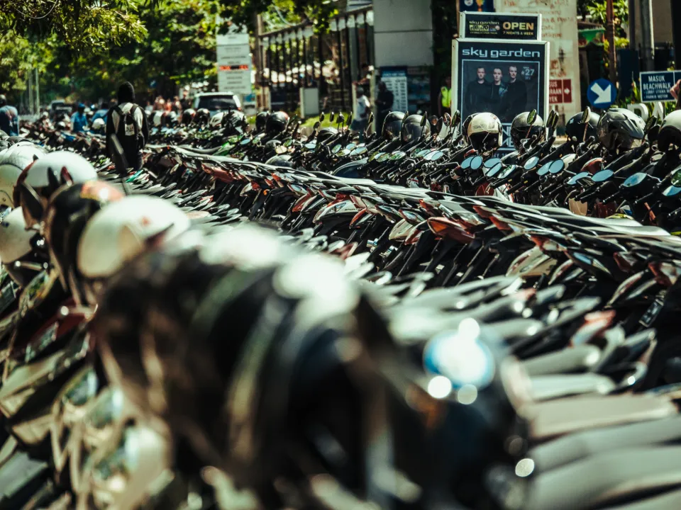 Long row of parked motorbikes along a city street